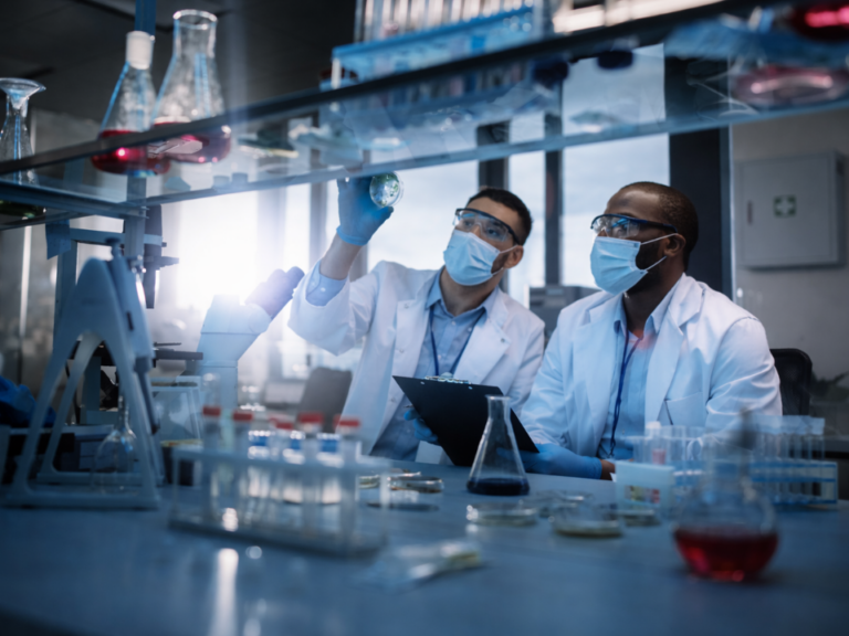 Profissionais em laboratório analítico realizando avaliação técnica de amostras, representando atividades de controle de qualidade e serviços analíticos terceirizados.