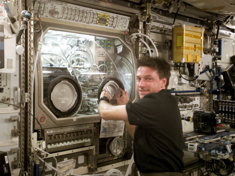 Ambiente experimental da Estação Espacial Internacional com sistemas laboratoriais utilizados em pesquisas científicas em microgravidade.
