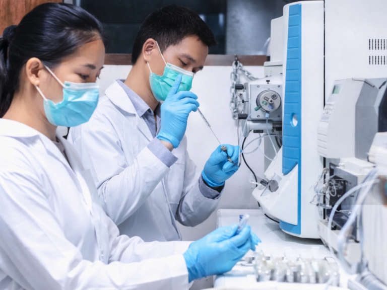 Técnicos realizando análise por espectrometria de massas em laboratório, com preparo de amostras e sistema LC-MS para aplicações analíticas avançadas.