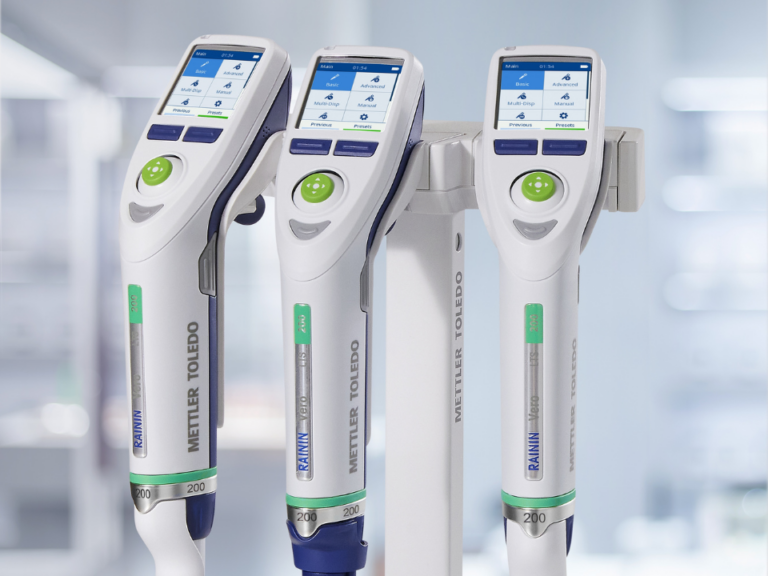 Pipetas eletrônicas Rainin Vero da METTLER-TOLEDO em suporte de bancada, com tela digital sensível ao toque e design ergonômico para pipetagem de alta precisão em laboratório.