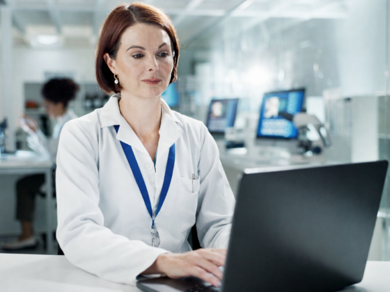 Profissional de laboratório utilizando computador em ambiente analítico moderno, com foco em gestão da qualidade laboratorial, organização de dados e rastreabilidade em sistema LIMS, cenário limpo e bem iluminado que representa eficiência operacional e cultura de qualidade.