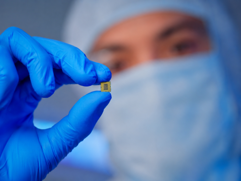 Pesquisador em ambiente laboratorial segura um espectrômetro miniaturizado com inteligência artificial integrado a microchip fotônico, destacando avanços em espectroscopia portátil e instrumentação analítica de alta precisão.